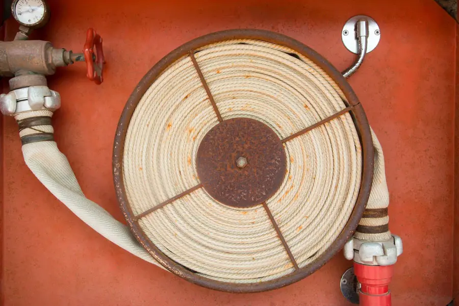 a white flat hose coiled on spool