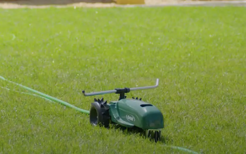 a travelling sprinkler moving along the grass