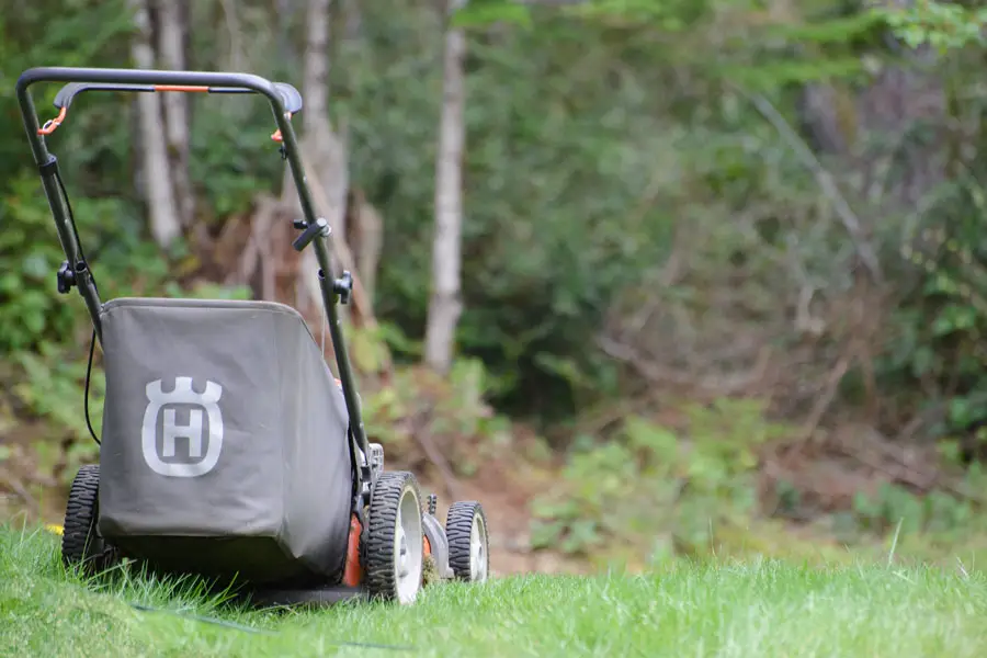 a lawn mower sitting on uncut grass