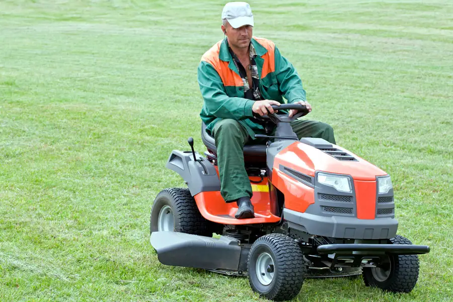 a man riding on a ride-on mower